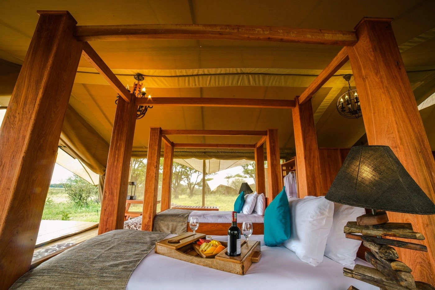 Suite bedroom with timber beams, a four-poster bed and a breakfast tray at Asanja Ruaha