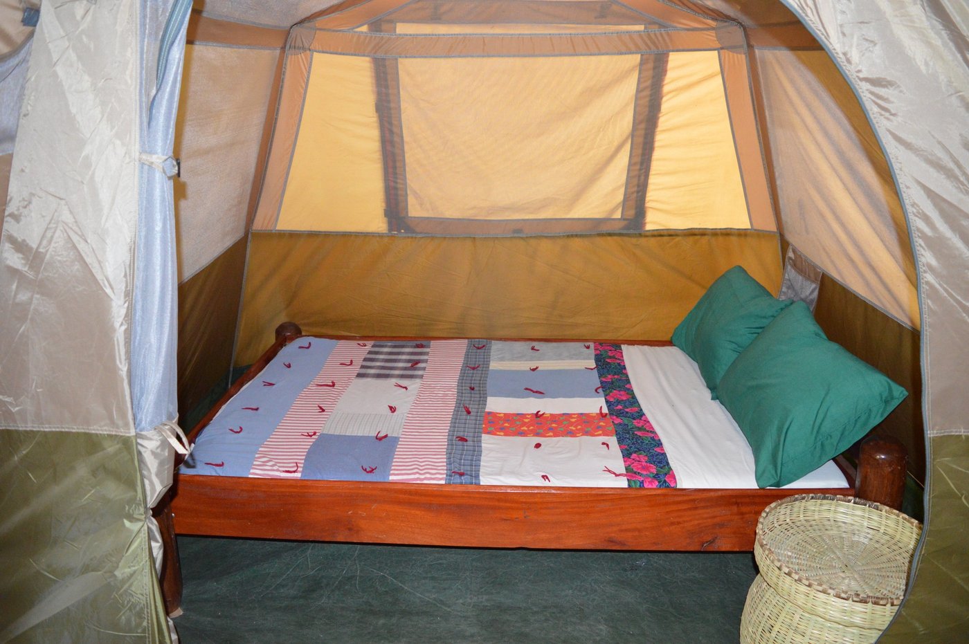 Permanent tent with a colorful African print bedspread at Chogela Safari Camp