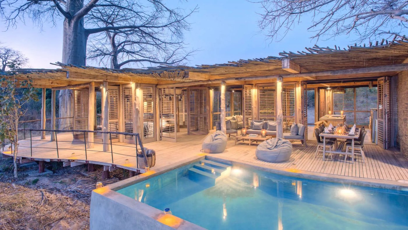 Private lap pool beside a thatched pavilion and sun loungers at Jabali Private House