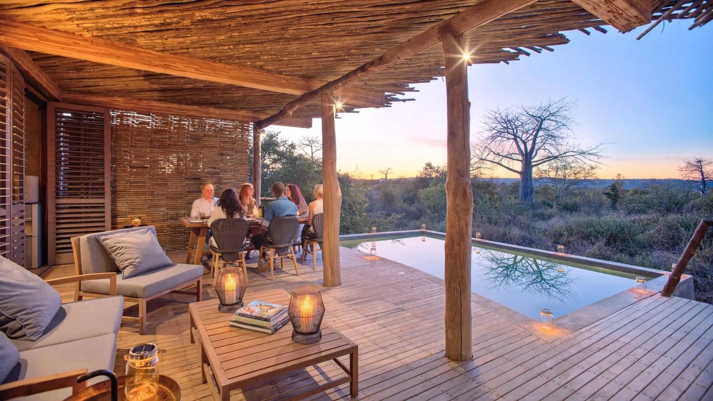 Thatched dining deck with sunset views over the bush at Jabali Private House