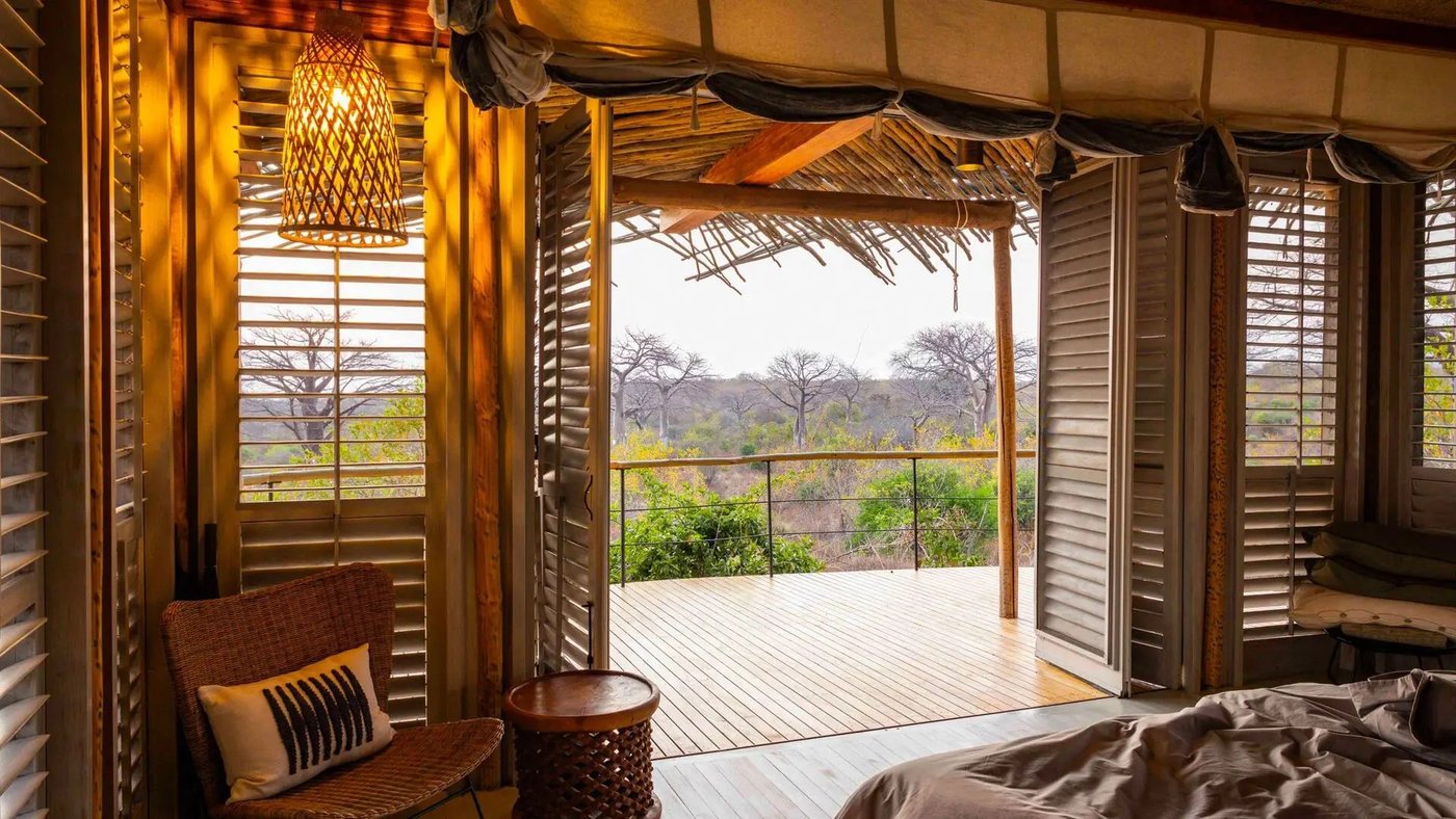 Bedroom with louvred shutters opening onto a private deck at Jabali Ridge
