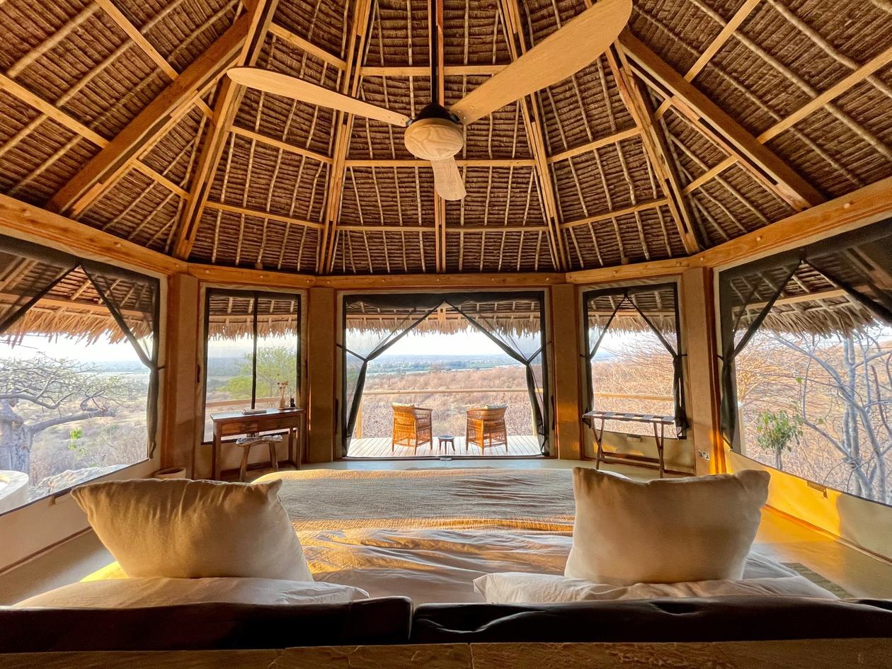 Domed bedroom pavilion opens to chairs and a sweeping valley view at Kichaka Expeditions