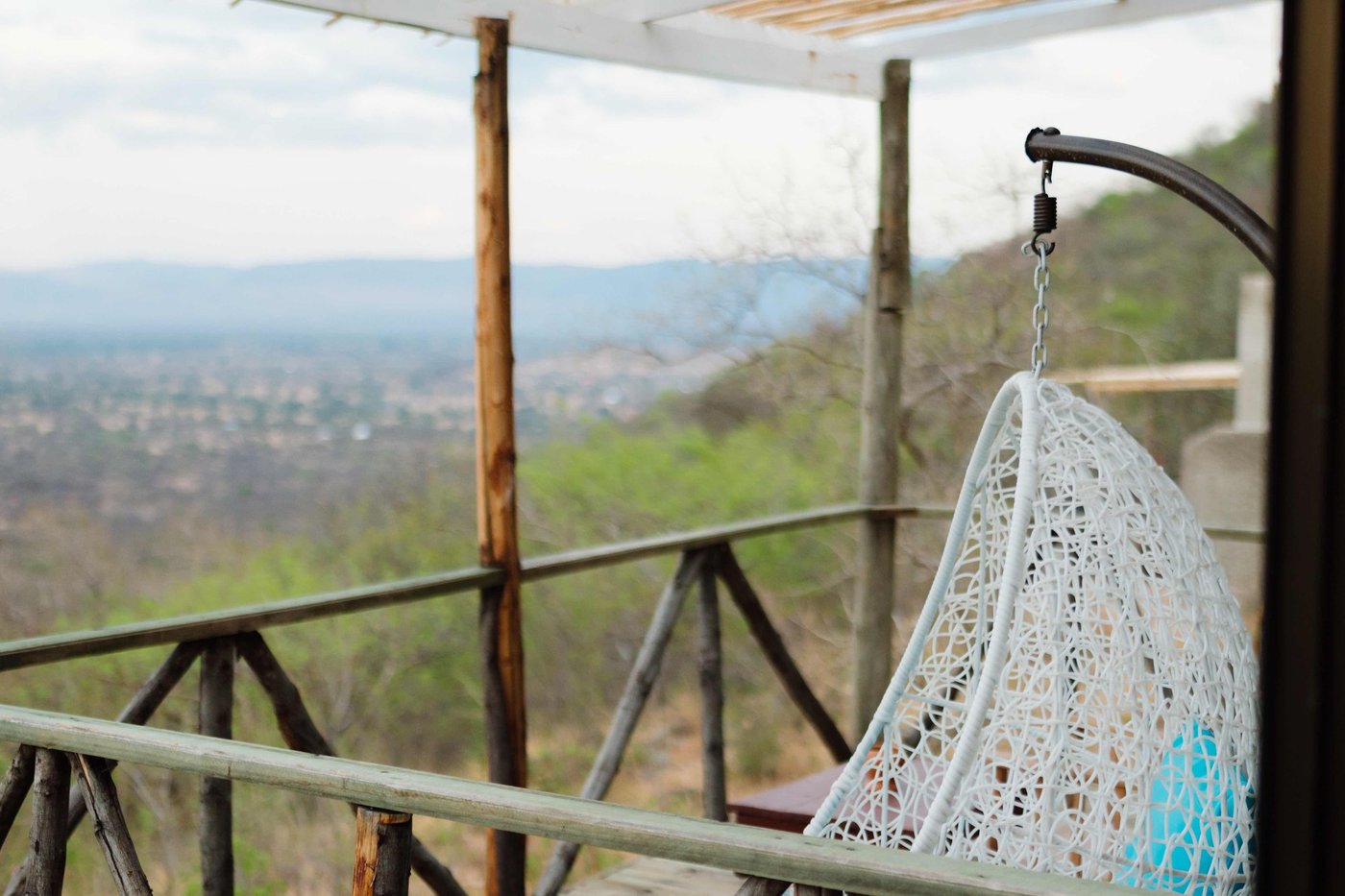 Hanging egg chair on a deck overlooking distant mountains at Ruaha Hilltop Lodge